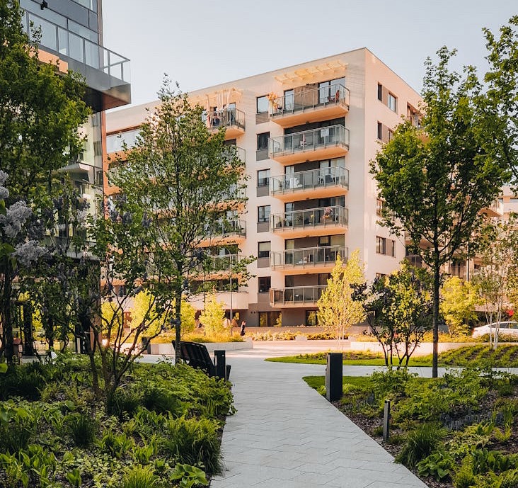 Mid-rise apartment building surrounded by green space and narrow pathway for walking. A very human-centric design, fit for the future.